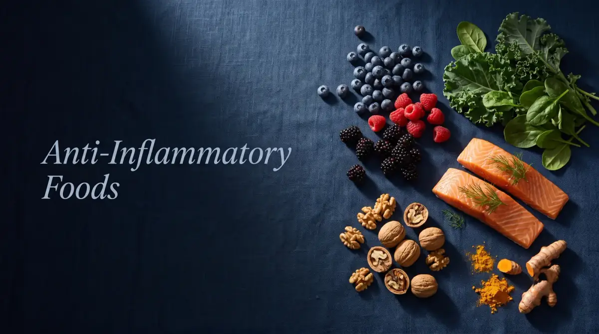 an overhead still life of berries, leafy greens, salmon, walnuts and turmeric spaced apart on linen