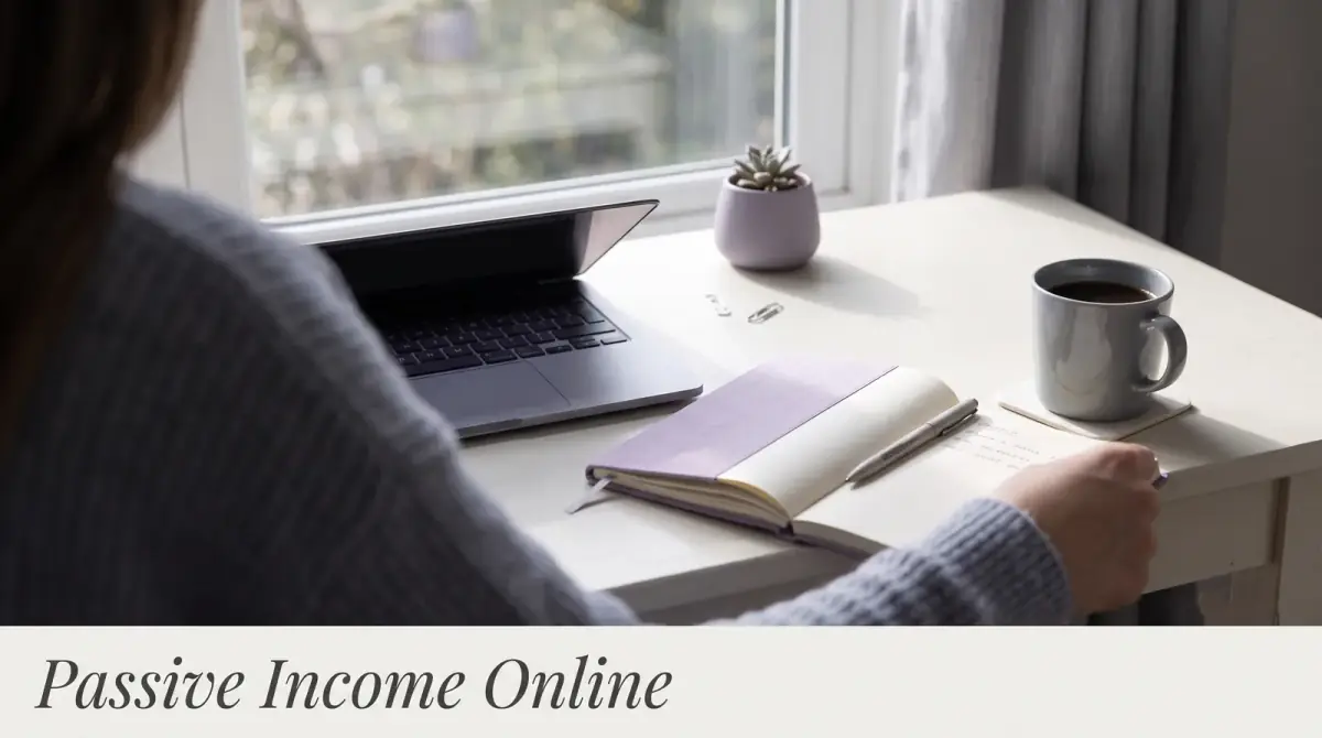 a laptop on a tidy desk by a window with an open notebook and a coffee