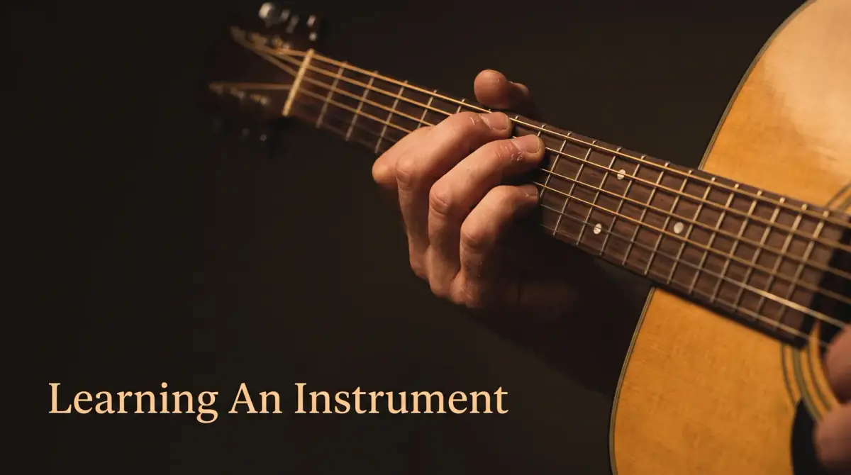 a hand fretting chords on an acoustic guitar neck