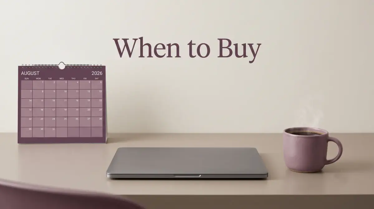 a wall calendar and a coffee mug on a desk beside a closed laptop