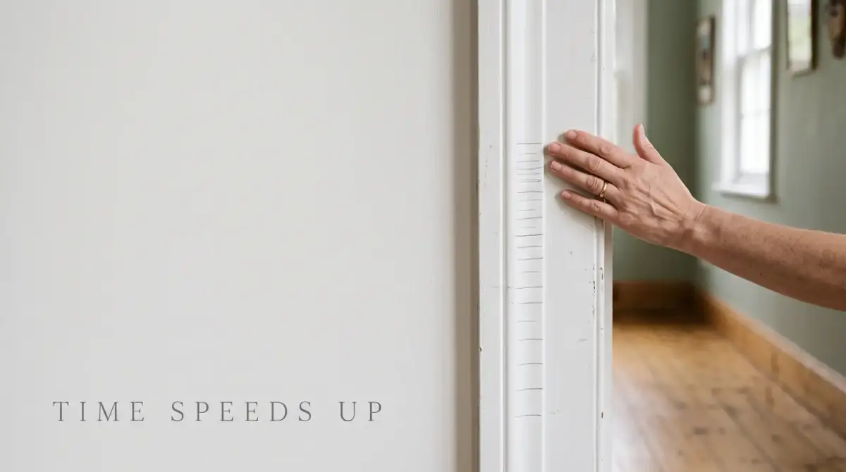 a hand touching pencilled height marks on a white door frame