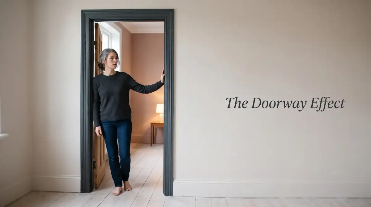 a woman standing in the open doorway of a bright home